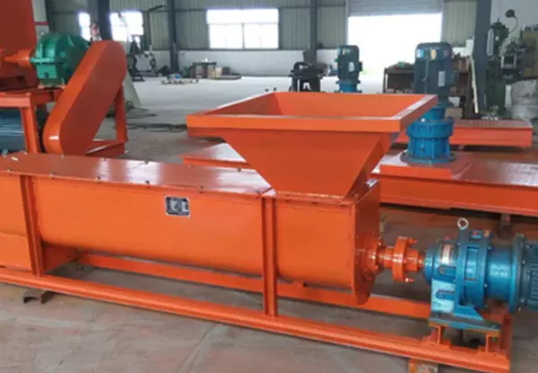 Industrial Screw Feeders: Critical Params & Selection Rules 2 An orange U-shaped screw feeder (open trough screw conveyor) with a hopper and motor, featured in an industrial workshop. Its open square trough design allows for easy cleaning and maintenance, making it suitable for scenarios with large material flow and easy residue accumulation.