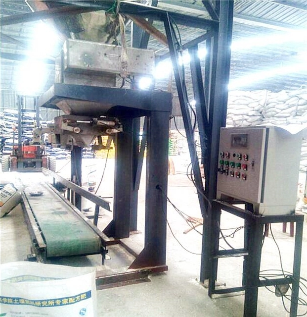 Packaging Machine Troubleshooting Guide: Fix Weighing Errors, Conveyor Jams & More 30 An industrial automatic quantitative packaging machine (for materials like cement/powder) with a metal frame, hopper, conveyor belt, and control panel, located in a factory workshop with stacked bags.
